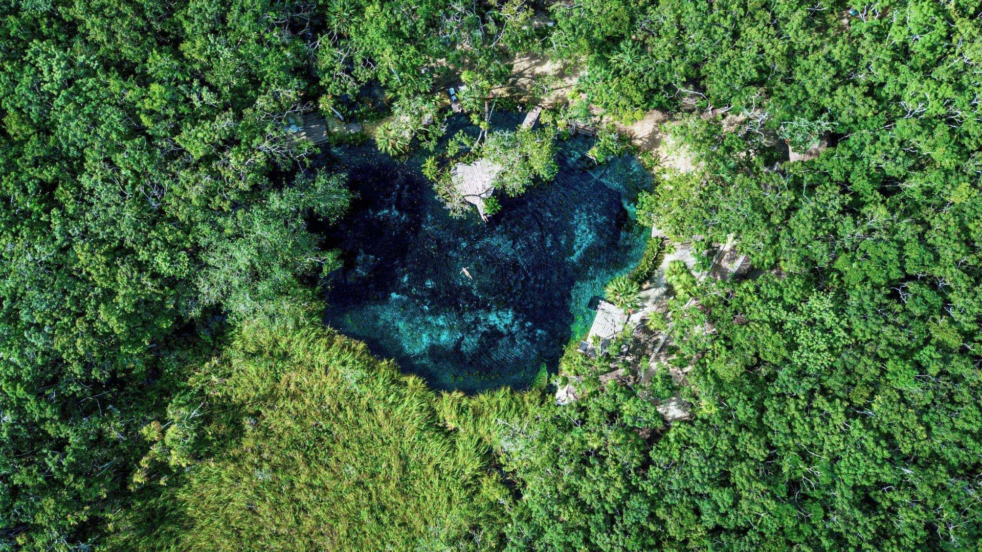 Swim in a secluded jungle cenote, where turquoise freshwater pools offer a refreshing escape on Contiki's Tulum to Antigua Tour