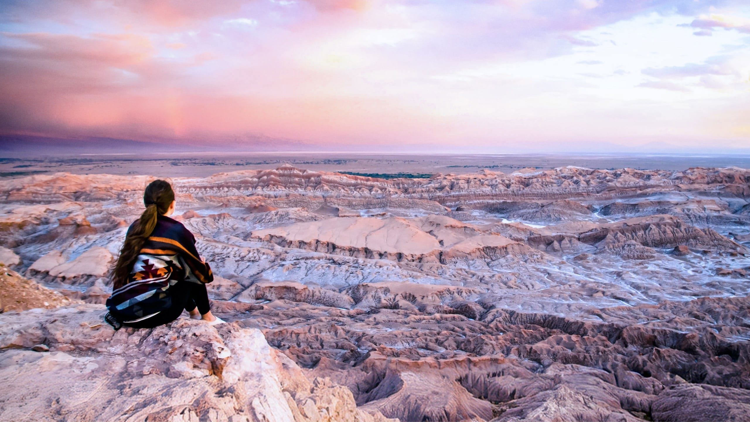 Traveller overlooking the otherworldly landscapes of Valle de la Luna in Chile's Atacama Desert at sunset on Contiki's La Paz to Buenos Aires Tour