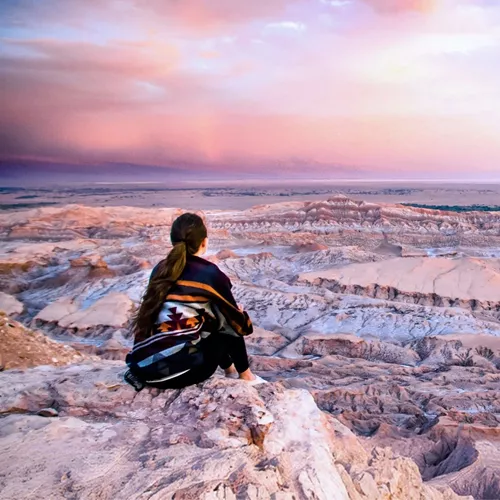 Traveller overlooking the otherworldly landscapes of Valle de la Luna in Chile's Atacama Desert at sunset on Contiki's La Paz to Buenos Aires Tour