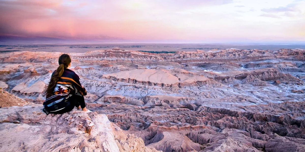 Traveller overlooking the otherworldly landscapes of Valle de la Luna in Chile's Atacama Desert at sunset on Contiki's La Paz to Buenos Aires Tour