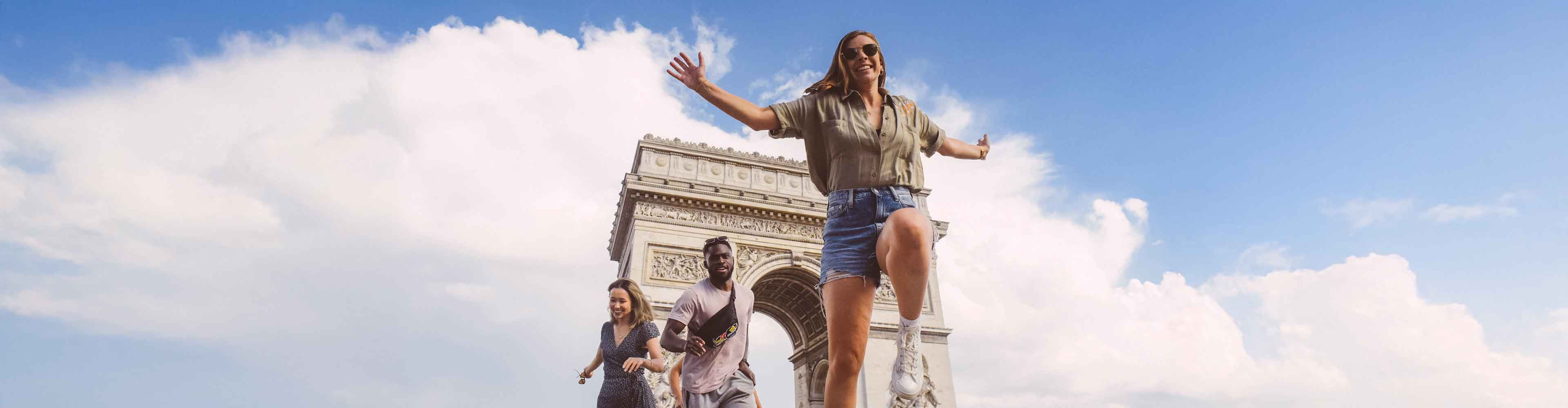 Group of young travelers having fun near Arc De Triomphe in Paris, France