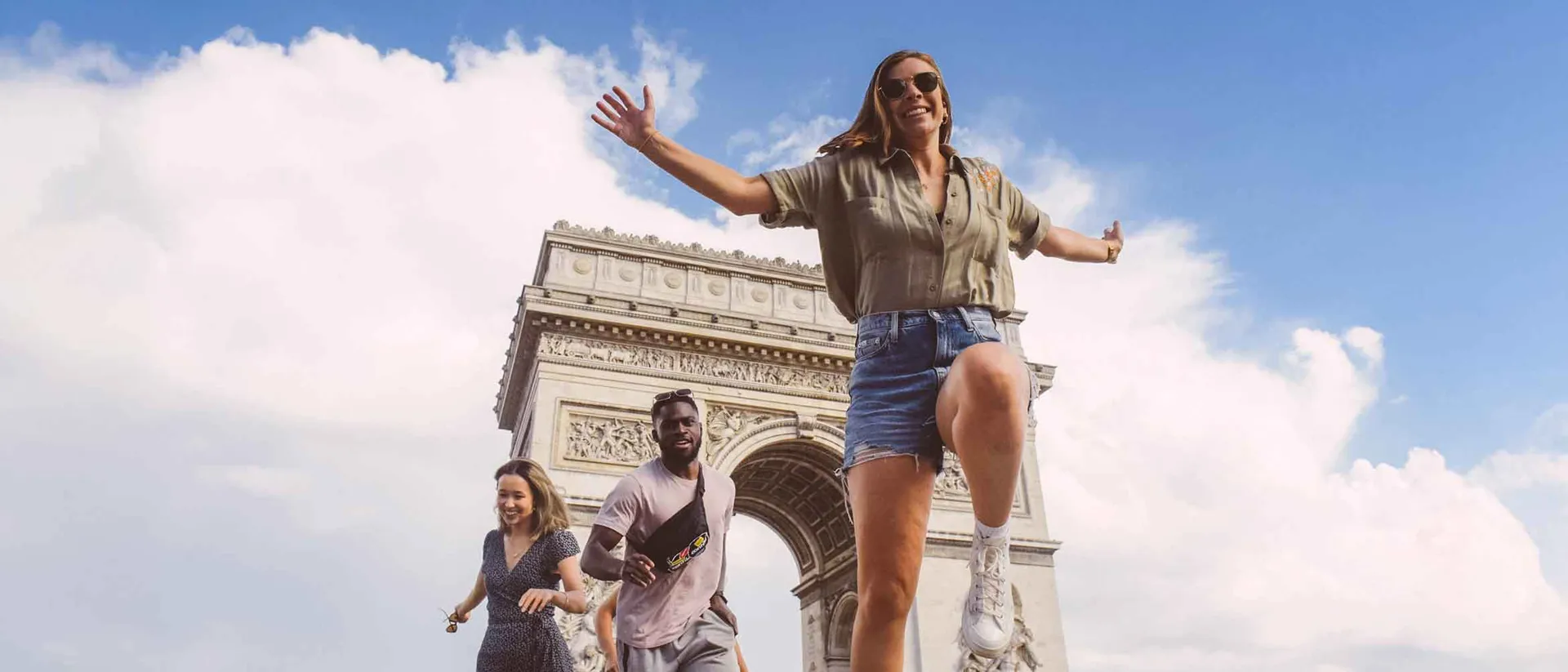 Group of young travelers having fun near Arc De Triomphe in Paris, France