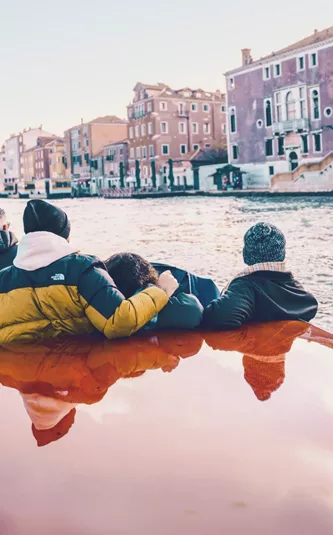 Travellers cruising through Venice by water taxi - Contiki Barcelona to London Quest Tour