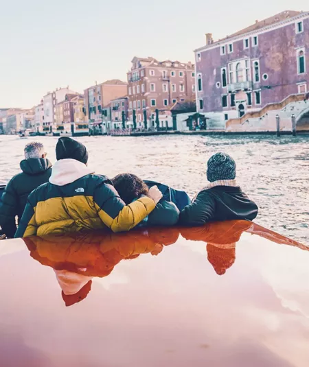 Travellers cruising through Venice by water taxi - Contiki Barcelona to London Quest Tour