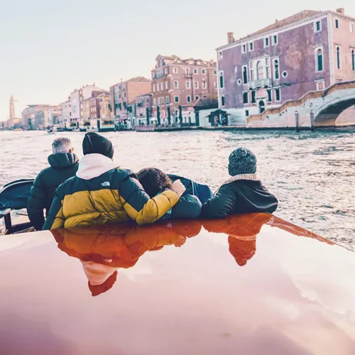 Travellers cruising through Venice by water taxi - Contiki Barcelona to London Quest Tour