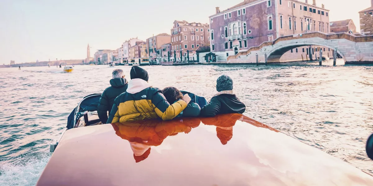 Travellers cruising through Venice by water taxi - Contiki Barcelona to London Quest Tour