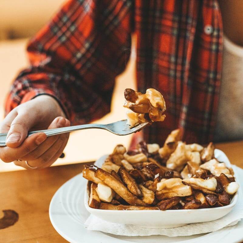 Person eating Montreal French Fries
