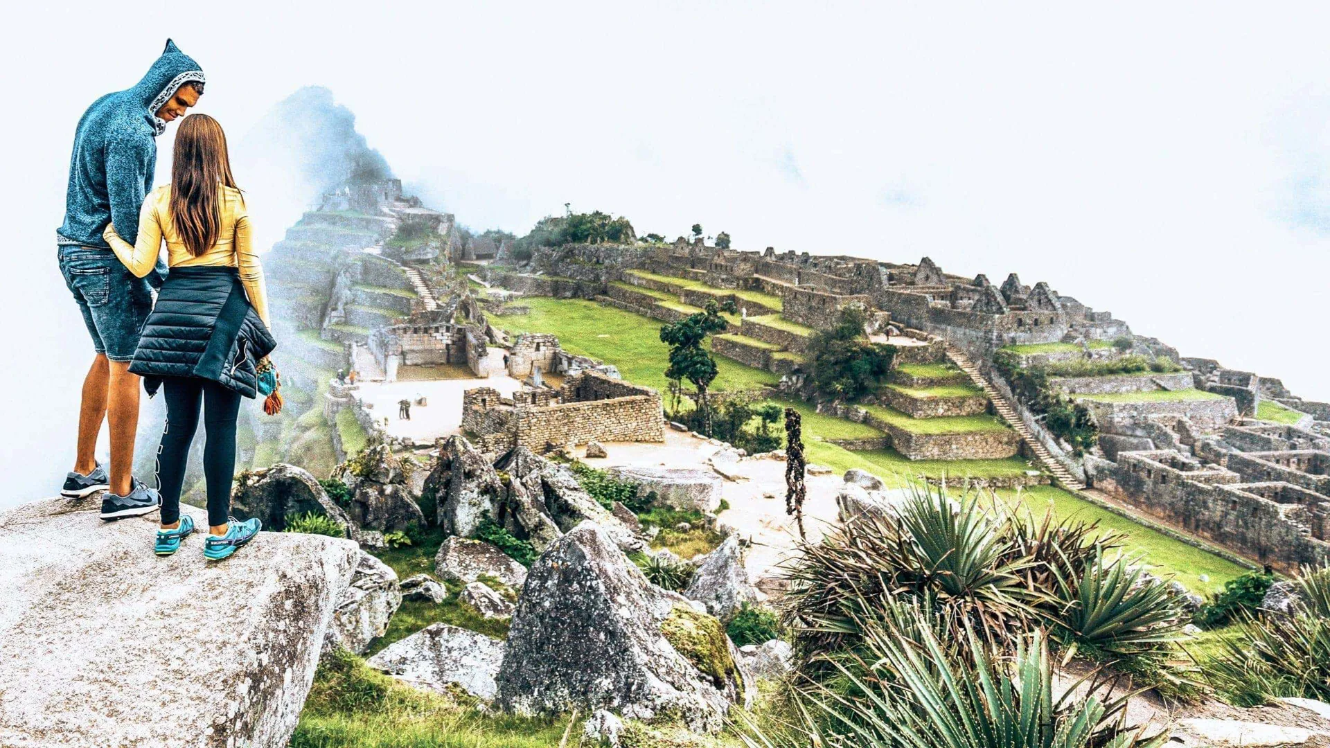 Machu Picchu emerges through the clouds as Contiki travellers admire Peru's iconic Inca citadel on Contiki's Lima to La Paz Tour