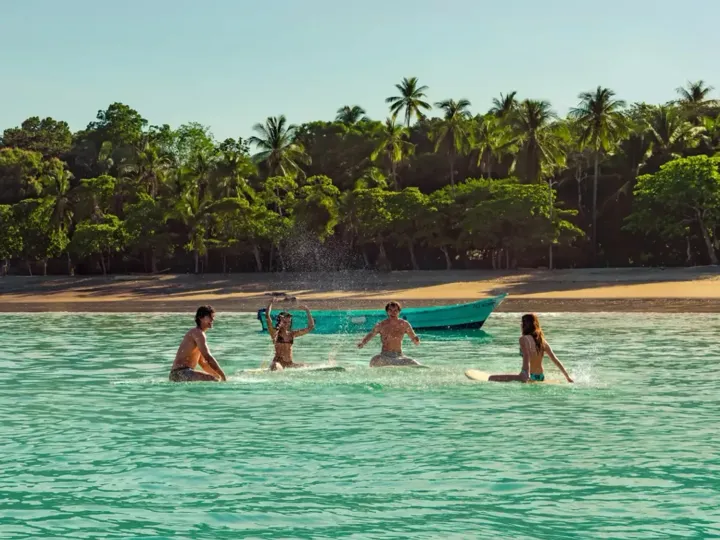 Group of travellers surfing in Costa Rica in January