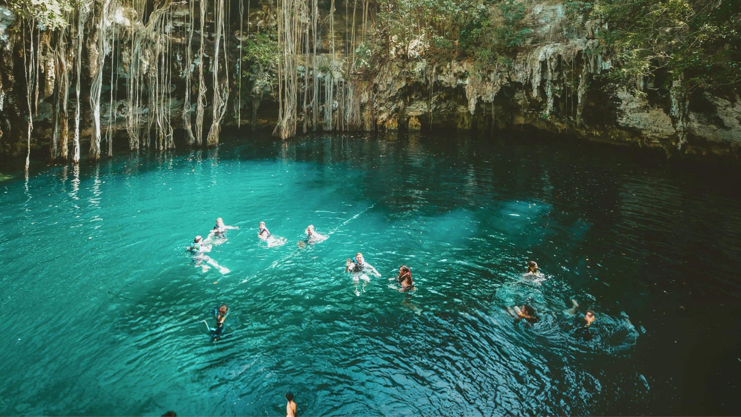 A group swimming in a natural cenote on Contiki's Mexico, Belize & Guatemala Tour