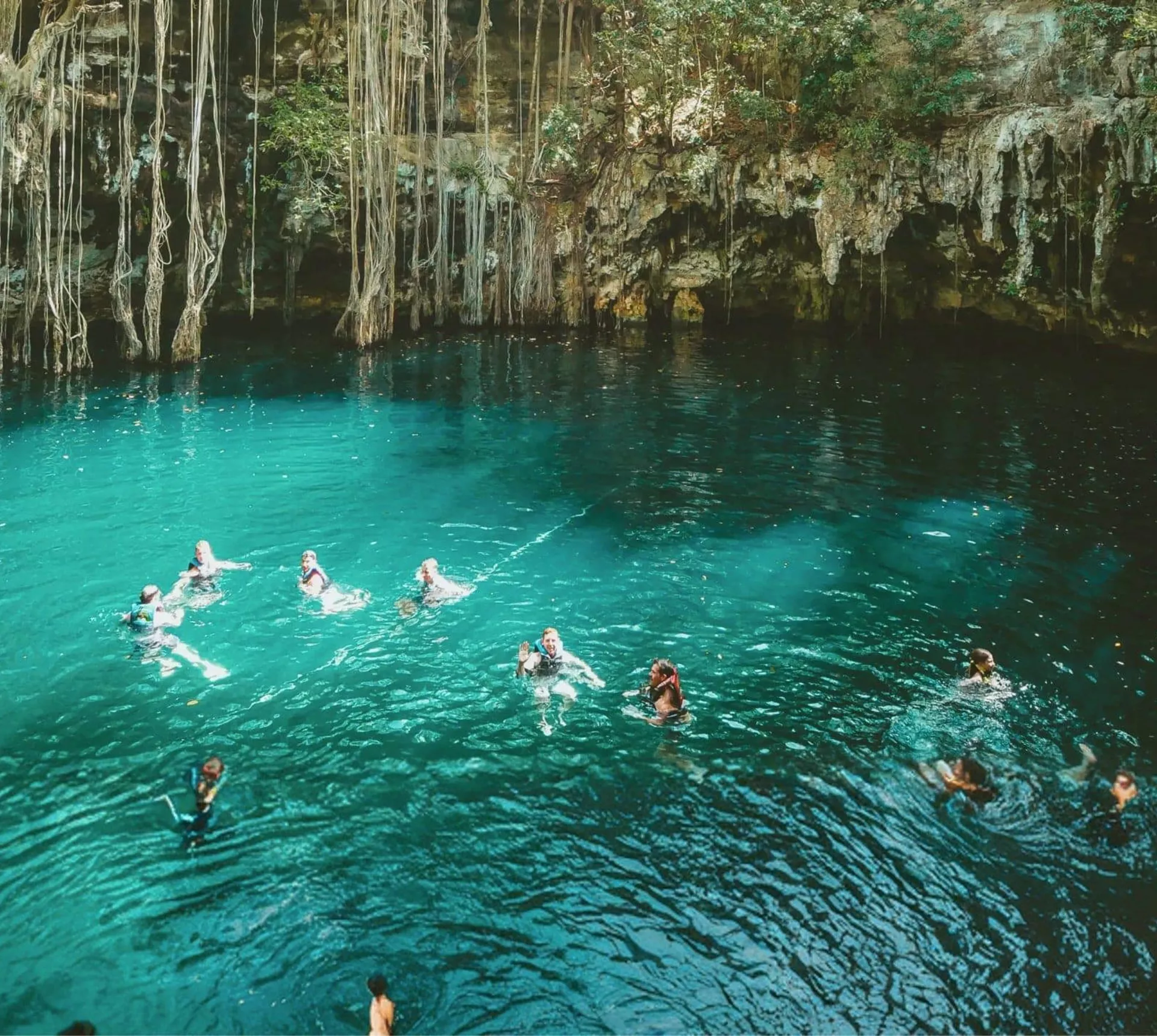 A group swimming in a natural cenote on Contiki's Mexico, Belize & Guatemala Tour