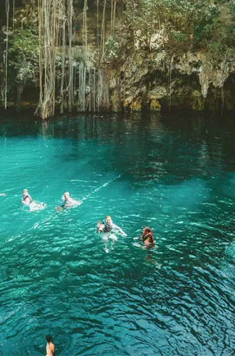 A group swimming in a natural cenote on Contiki's Mexico, Belize & Guatemala Tour