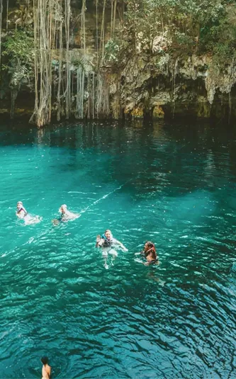 A group swimming in a natural cenote on Contiki's Mexico, Belize & Guatemala Tour