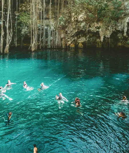 A group swimming in a natural cenote on Contiki's Mexico, Belize & Guatemala Tour