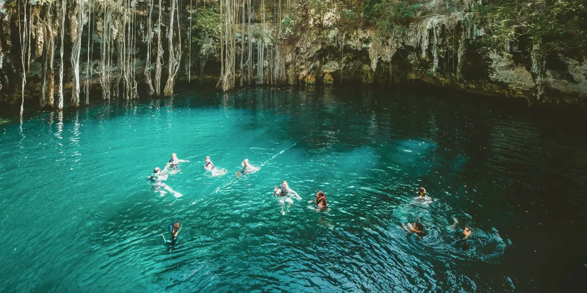 A group swimming in a natural cenote on Contiki's Mexico, Belize & Guatemala Tour