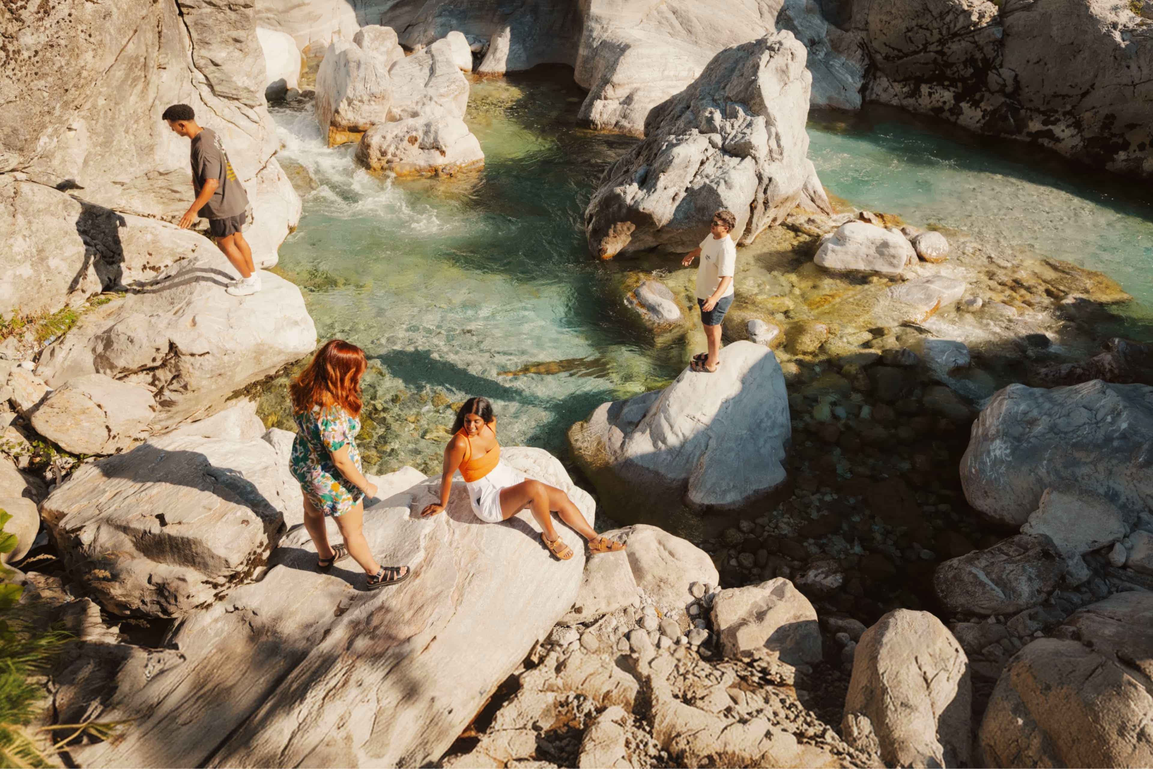 Travellers exploring the crystal-clear pools and limestone rocks of the Shala River, Albania.