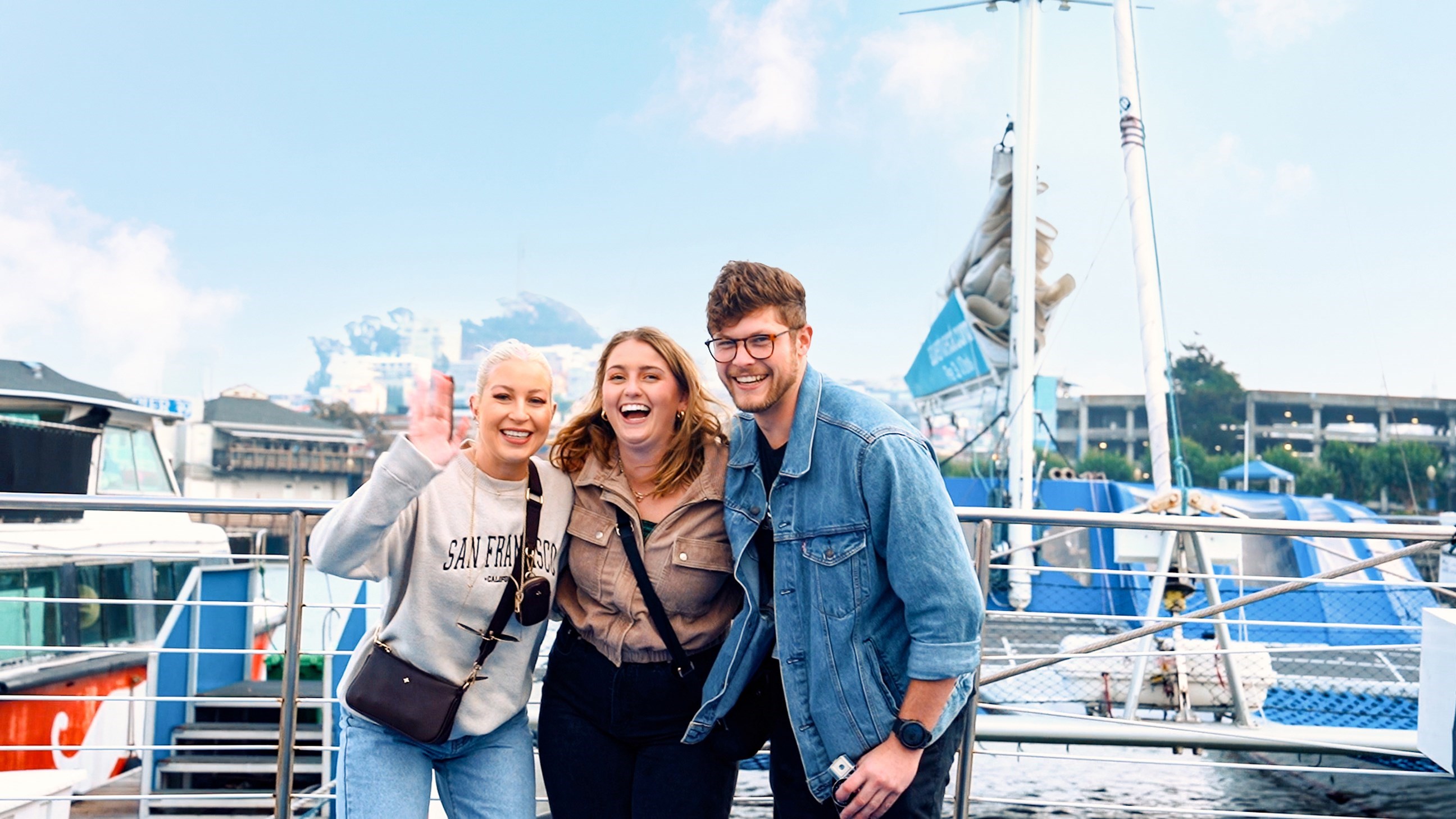 Three Travellers Smiling for Photo at Harbour in San Francisco, USA