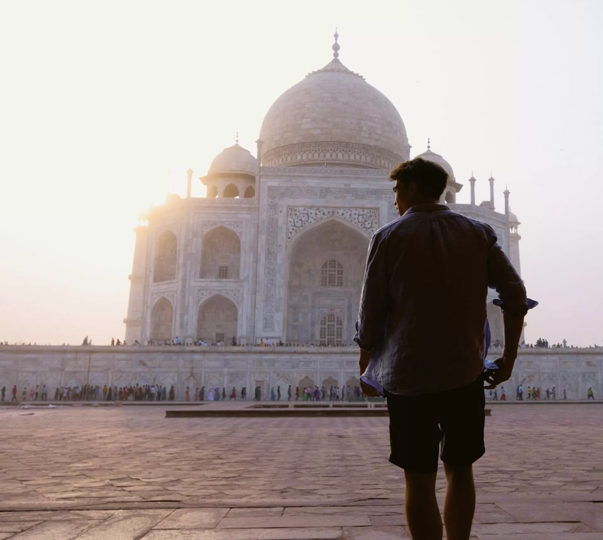 Sunrise illuminates the Taj Mahal as a Contiki traveller takes in India's most iconic monument on the Rajasthan & Golden Triangle Tour