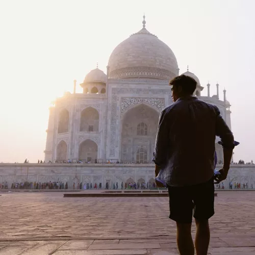 Sunrise illuminates the Taj Mahal as a Contiki traveller takes in India's most iconic monument on the Rajasthan & Golden Triangle Tour