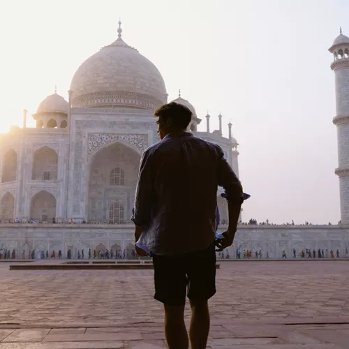 Sunrise illuminates the Taj Mahal as a Contiki traveller takes in India's most iconic monument on the Rajasthan & Golden Triangle Tour