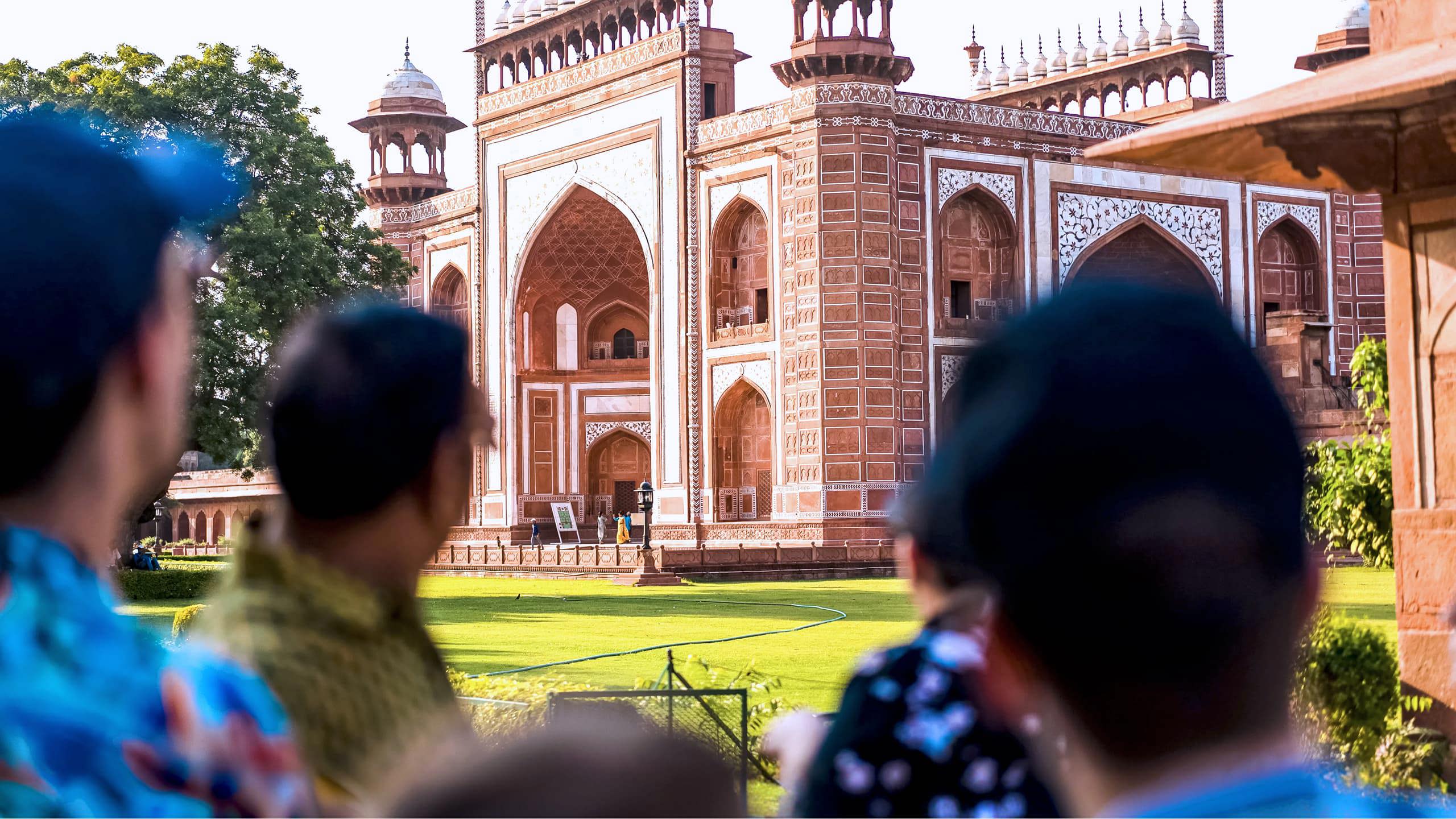 Travellers viewing the ornate red sandstone Great Gate entrance to the Taj Mahal in Agra India - Contiki India Northern Explorer Tour