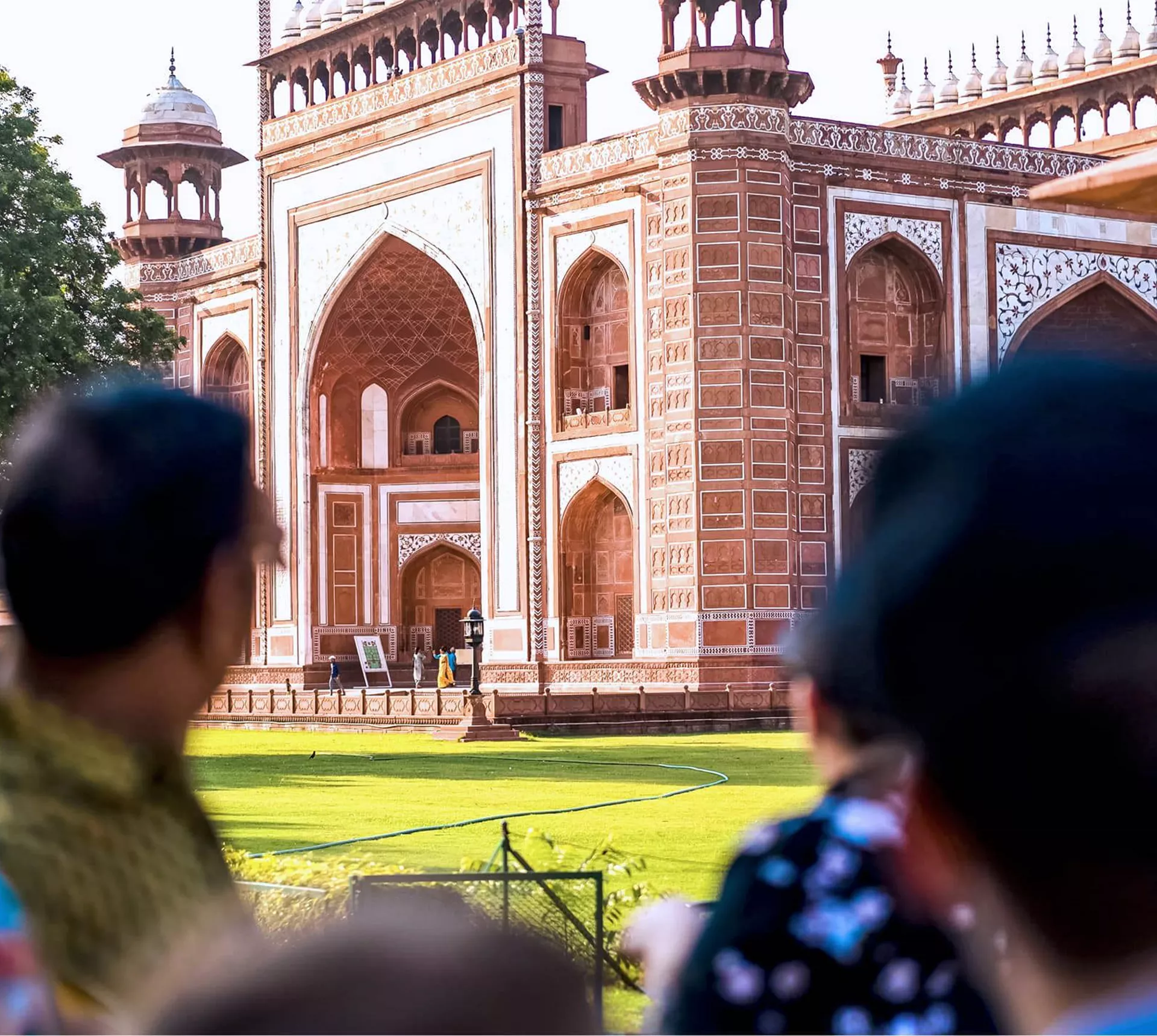 Travellers viewing the ornate red sandstone Great Gate entrance to the Taj Mahal in Agra India - Contiki India Northern Explorer Tour