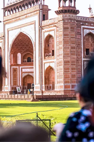 Travellers viewing the ornate red sandstone Great Gate entrance to the Taj Mahal in Agra India - Contiki India Northern Explorer Tour