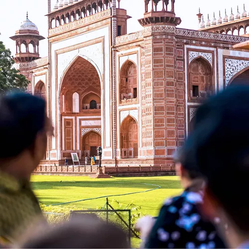 Travellers viewing the ornate red sandstone Great Gate entrance to the Taj Mahal in Agra India - Contiki India Northern Explorer Tour