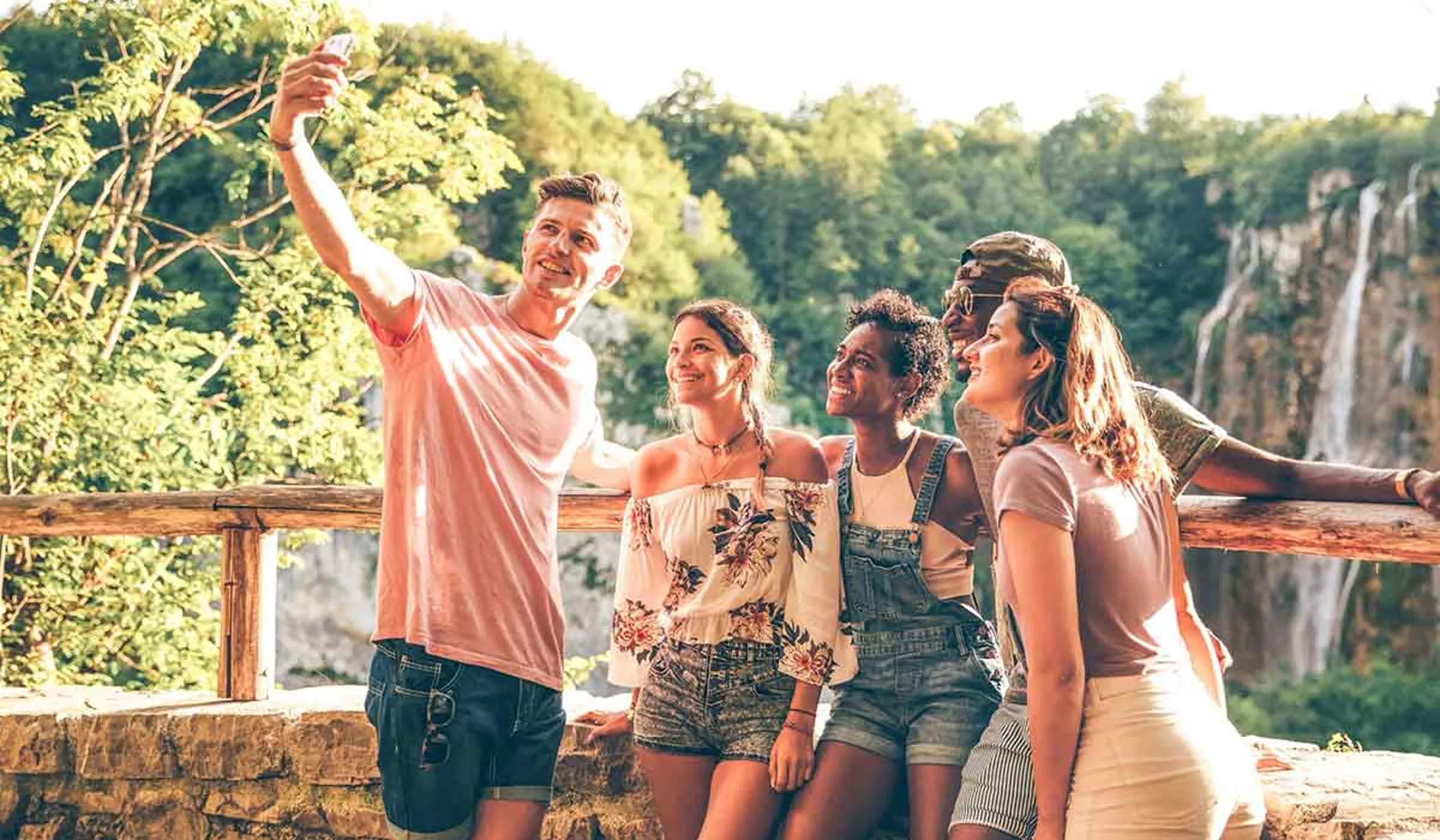 Group of young people taking selfie with a nature landscape at the background