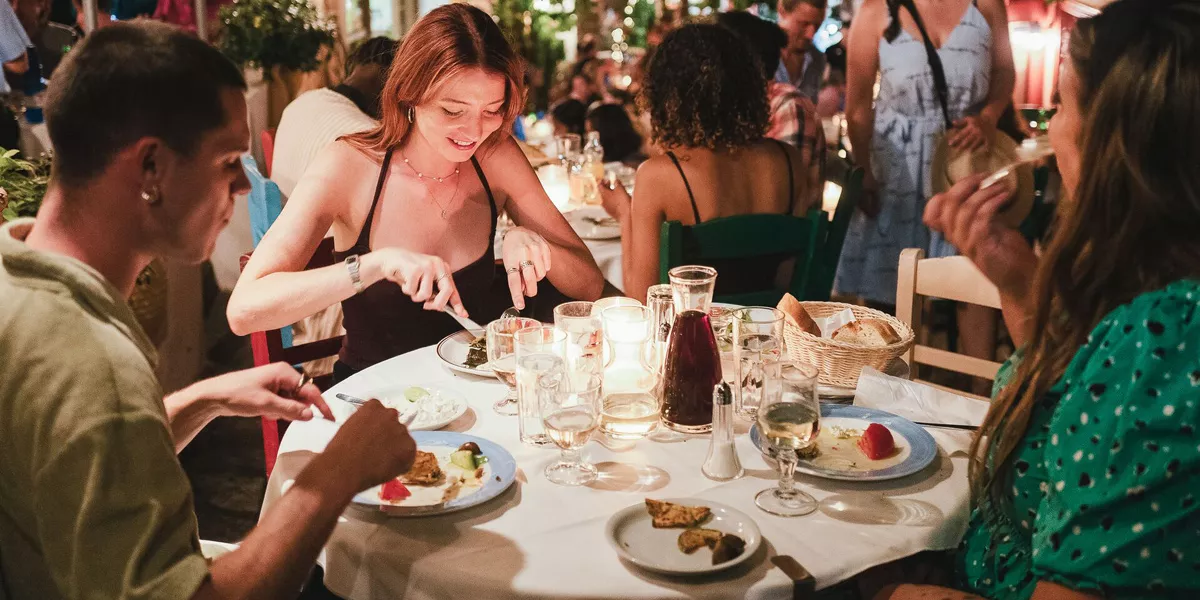 Friends Enjoying Dinner At A Restaurant Warm Weather