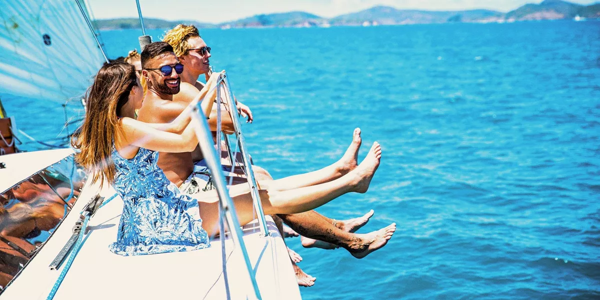 Turquoise waters, island views and a yacht under sail - Contiki travellers cruise through the Whitsundays on the journey to Cairns