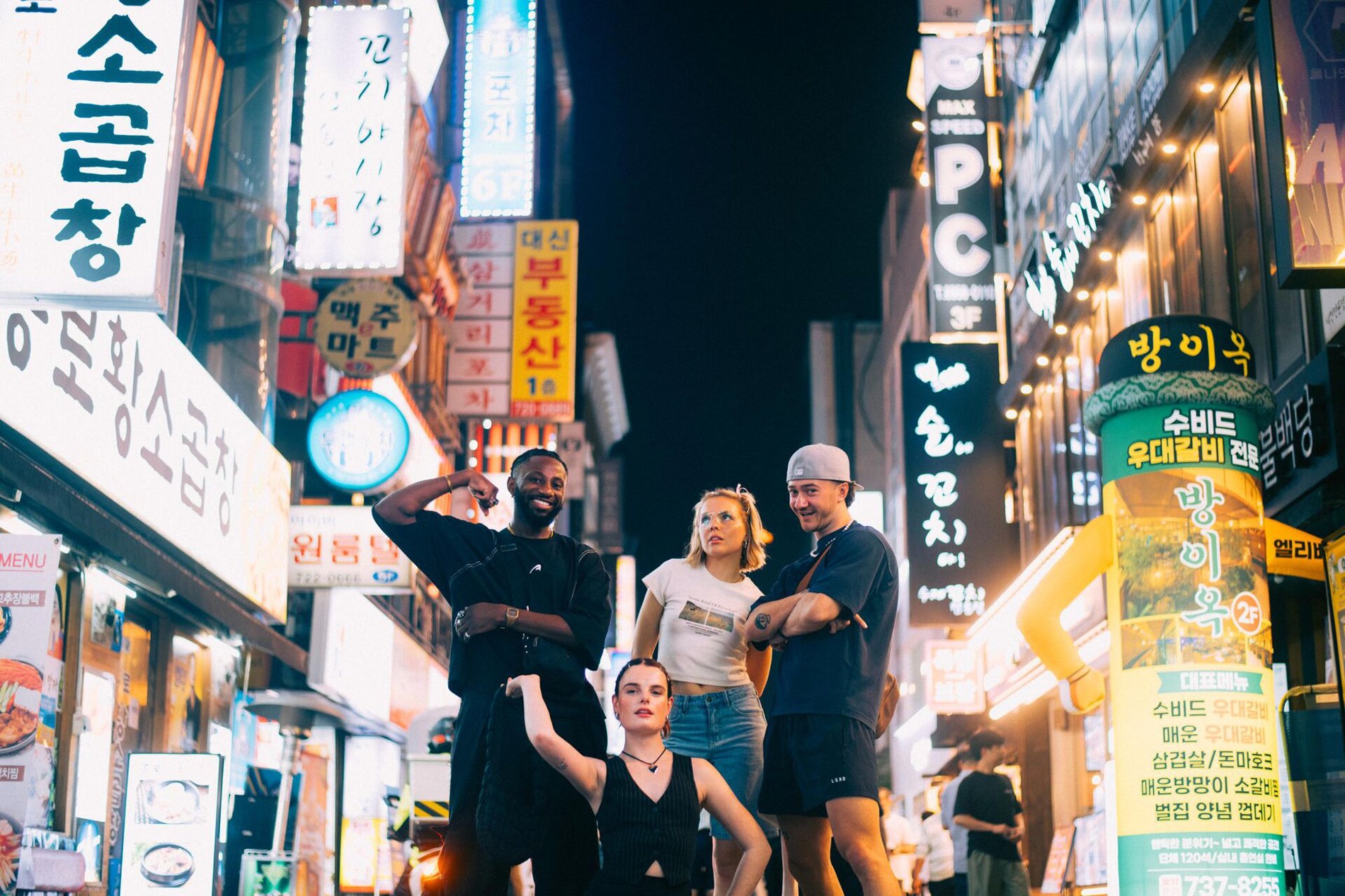 A group of people in the middle of a road with buildings around them in South Korea.