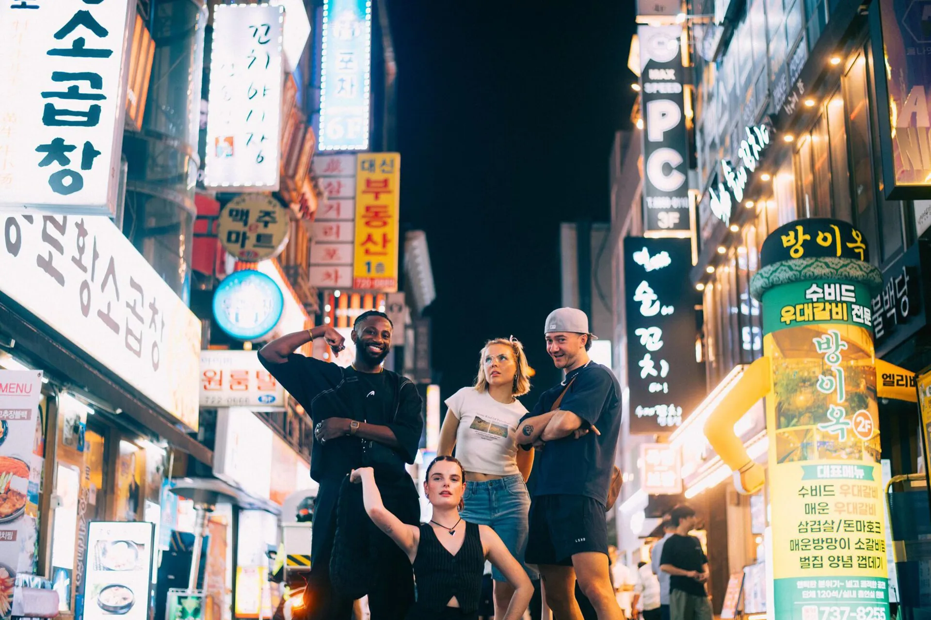 A group of people in the middle of a road with buildings around them in South Korea.