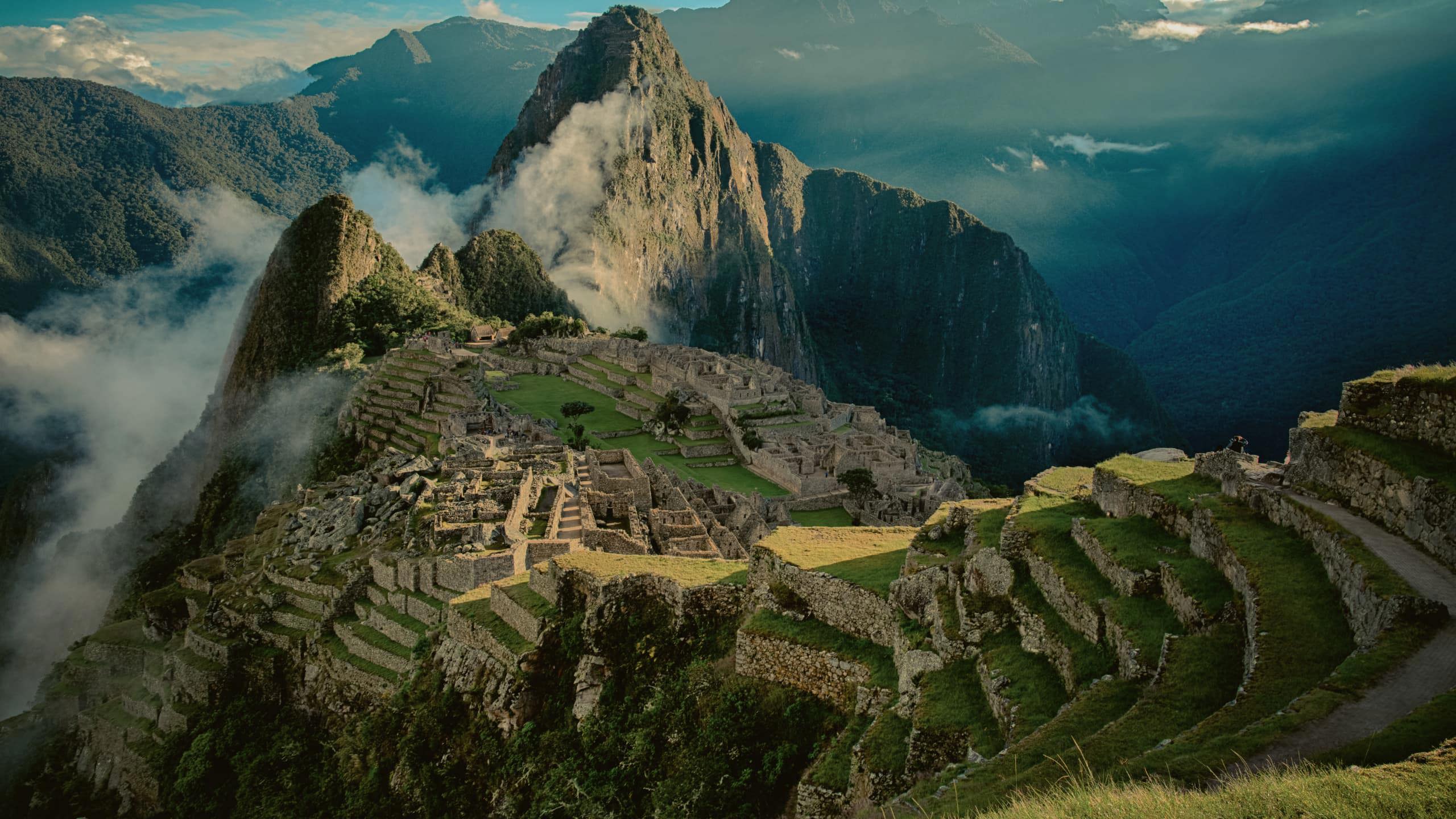 Panoramic aerial view of Machu Picchu ancient Inca citadel and terraces with cloud-covered Huayna Picchu mountain in the Sacred Valley Peru - Contiki Best of Peru Tour