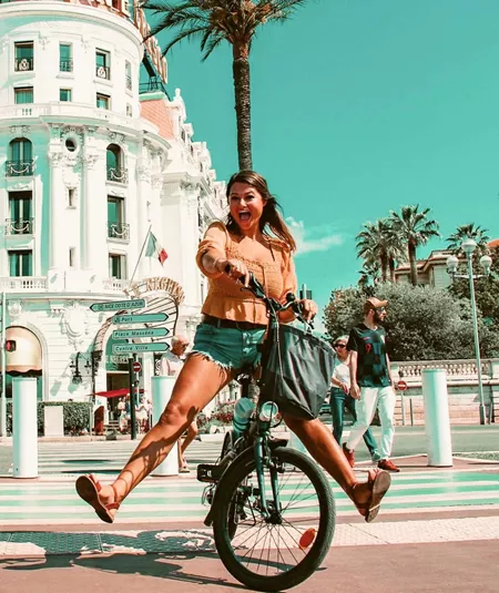 Traveller rides a bicycle through Nice, France, on the Contiki Barcelona to Rome Quest Summer Tour