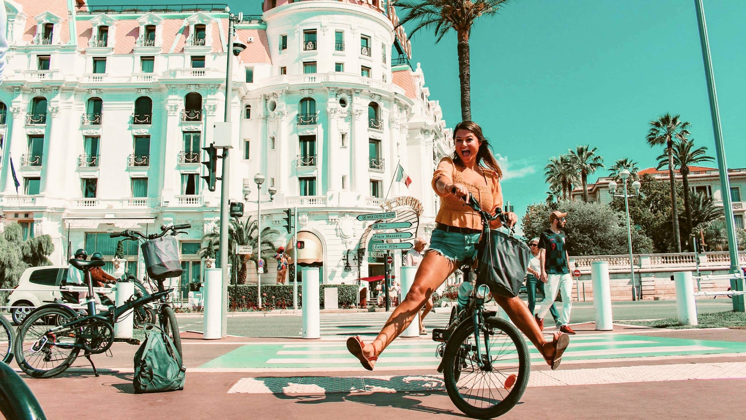 Traveller rides a bicycle through Nice, France, on the Contiki Barcelona to Rome Quest Summer Tour