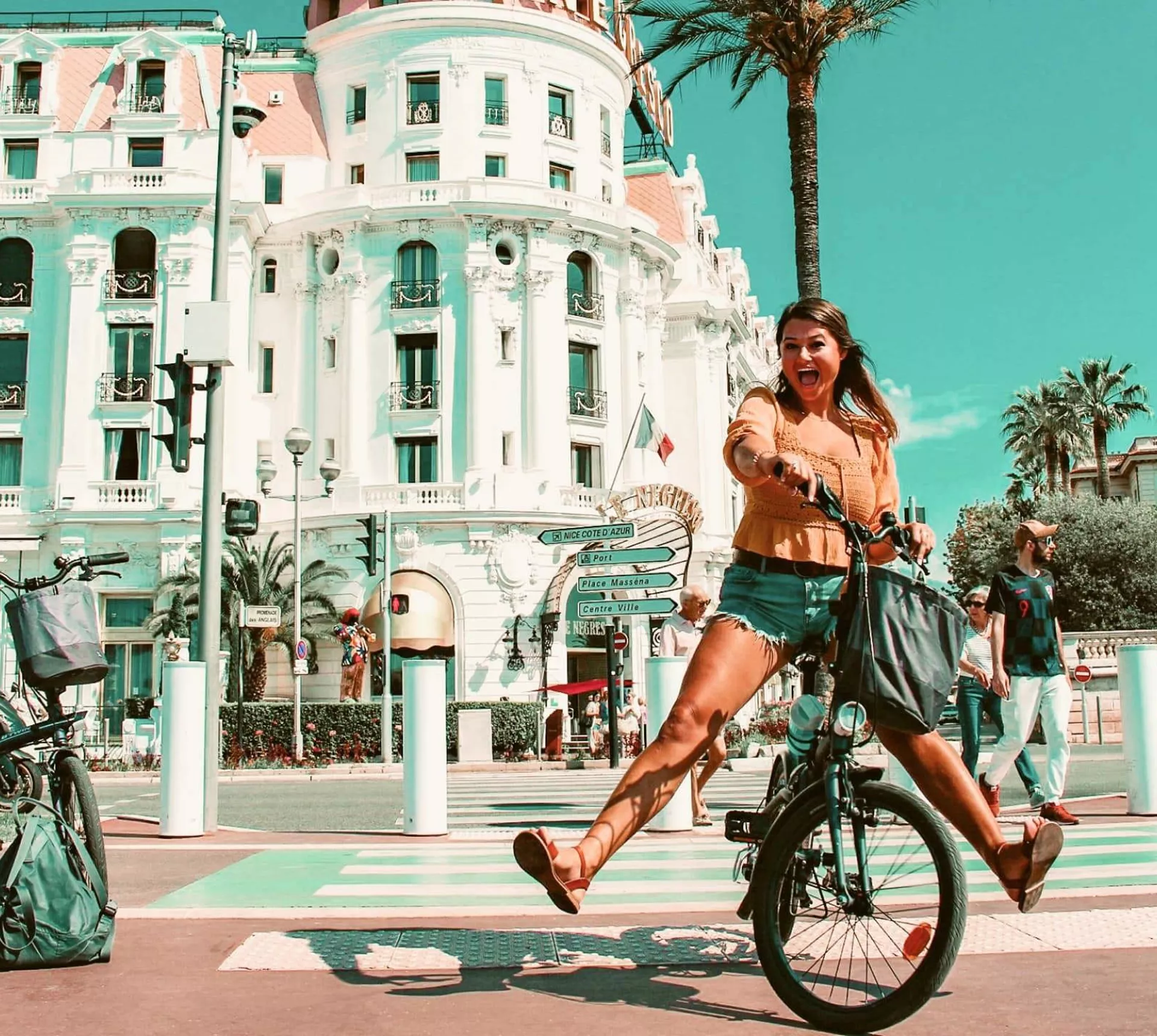 Traveller rides a bicycle through Nice, France, on the Contiki Barcelona to Rome Quest Summer Tour