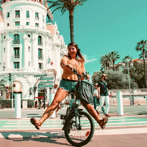 Traveller rides a bicycle through Nice, France, on the Contiki Barcelona to Rome Quest Summer Tour
