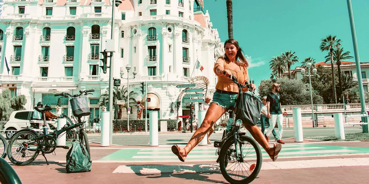 Traveller rides a bicycle through Nice, France, on the Contiki Barcelona to Rome Quest Summer Tour