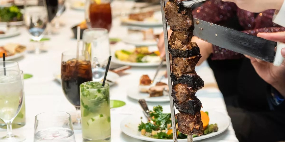 Serving meat on a restaurant table in Brazil.