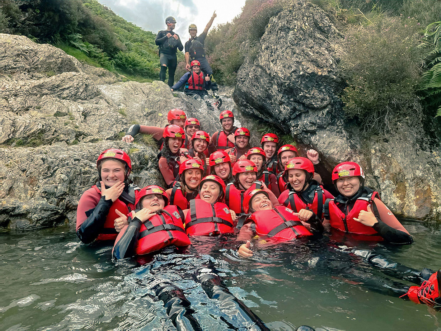 Travellers smiling whilst ghyll scrambling in the Lake District, United Kingdom