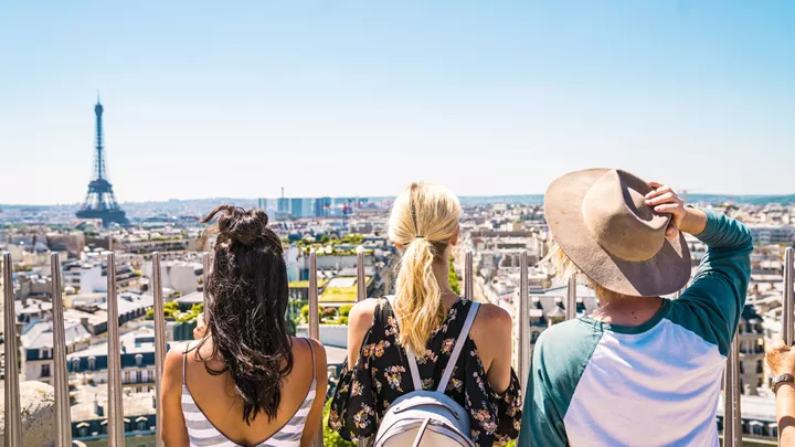 Travellers up the Arc de Triomphe with a view of the Eiffel Tower in Paris, France