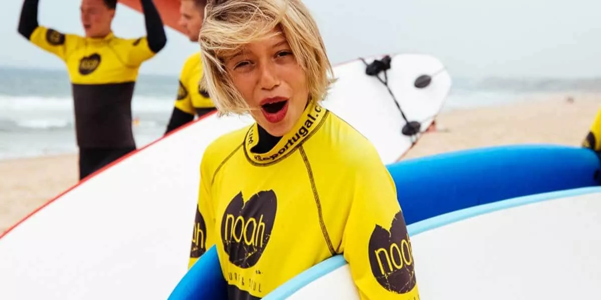 A boy with a funny expression holding a paddleboard