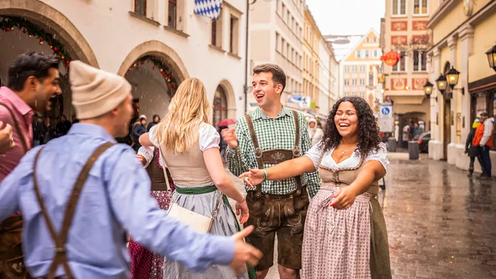 Travellers outside a beer hall, wearing their dirndls in Munich Germany