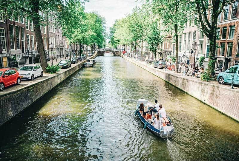Tourists going by boat along the water canal in the city