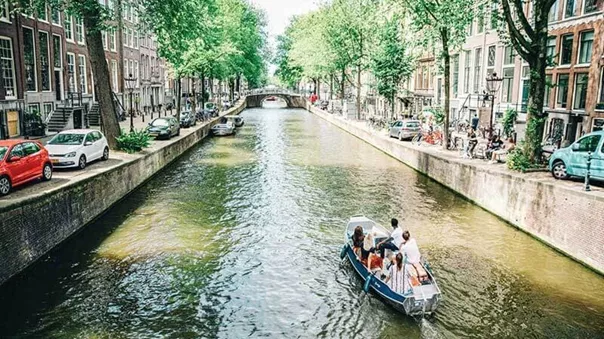 Tourists going by boat along the water canal in the city