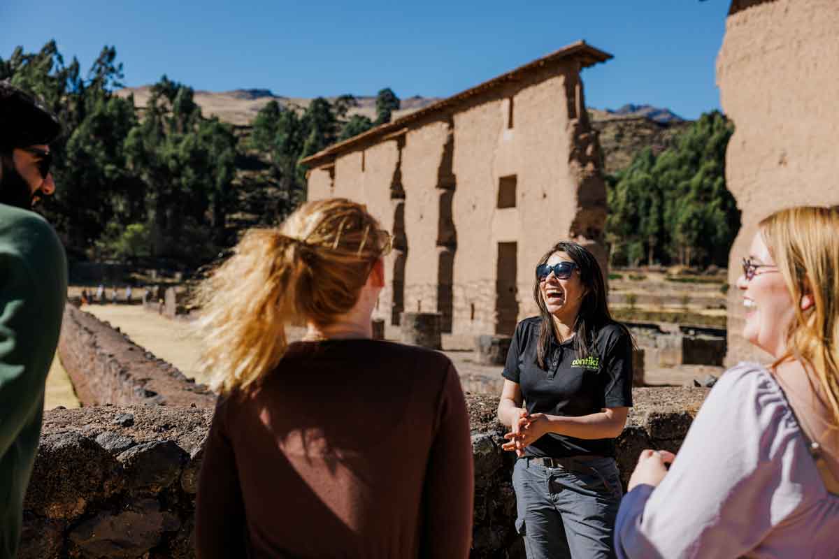Tour Guide In Peru Laughing With Group Of Travelers