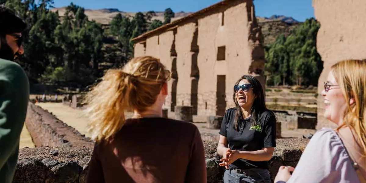 Tour Guide In Peru Laughing With Group Of Travelers