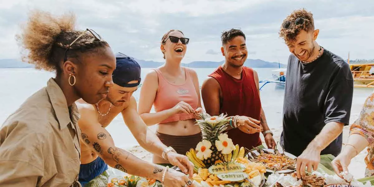 Young Friends Enjoying Food At The Beach
