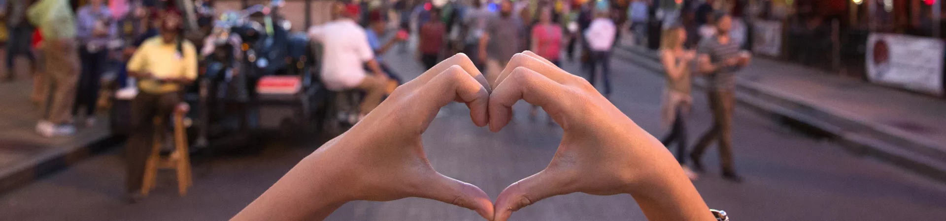 City view, girl making heart with hands